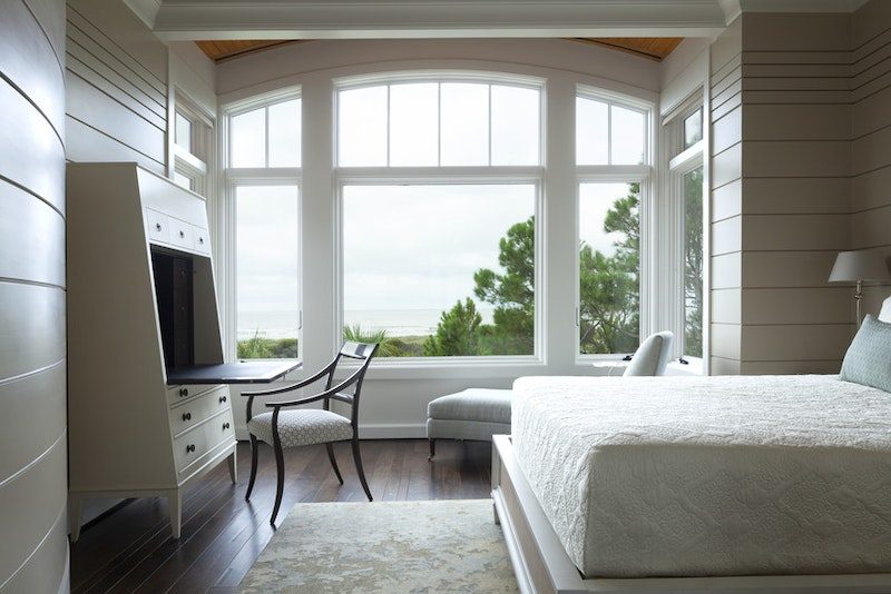 white-woodclad-arched-windows-in-a-guest-bedroom